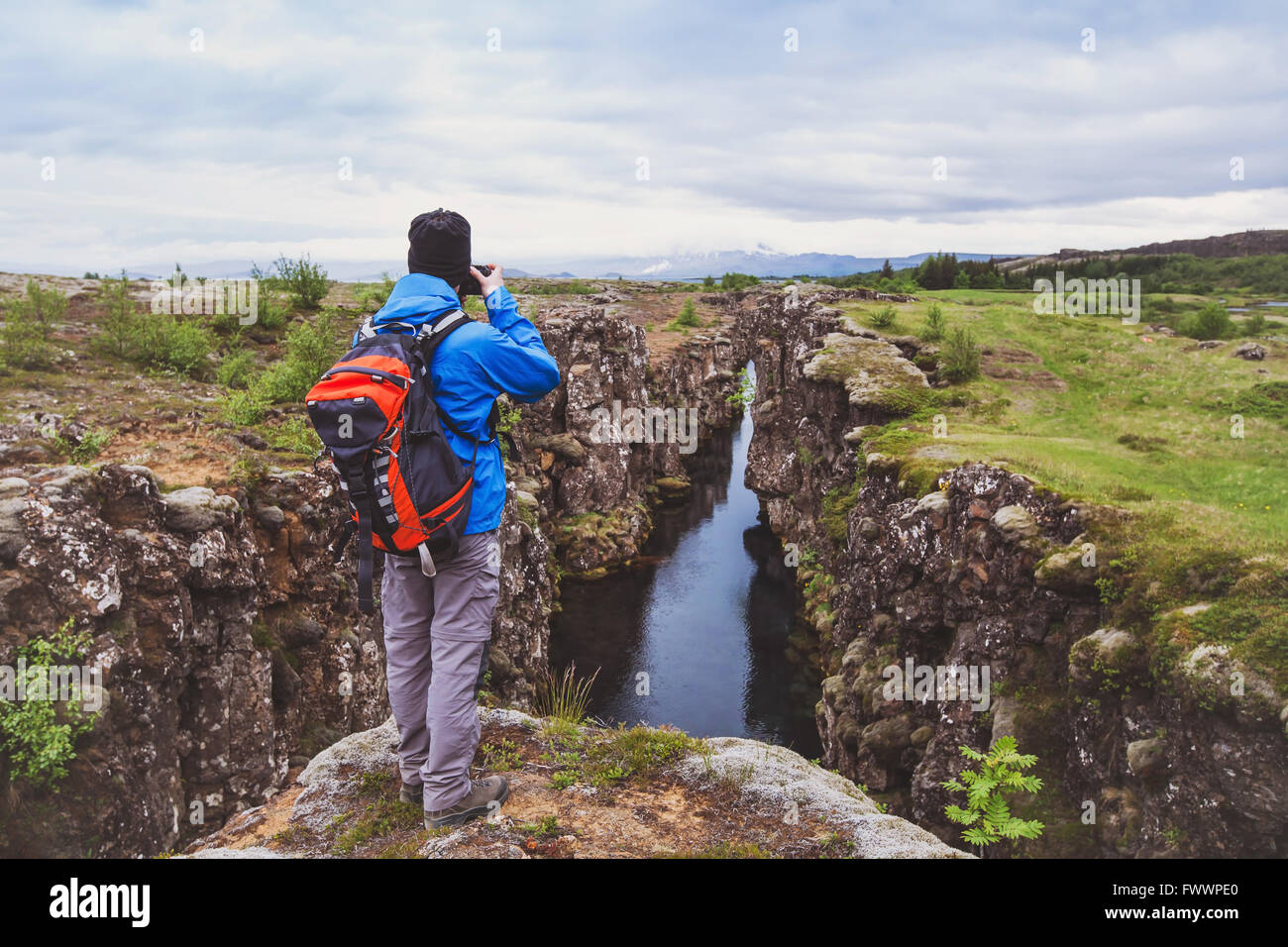 Naturfotograf, Wanderer mit Rucksack, die Aufnahme der schönen Landschaft in Island Nationalpark Thingvellir Stockfoto