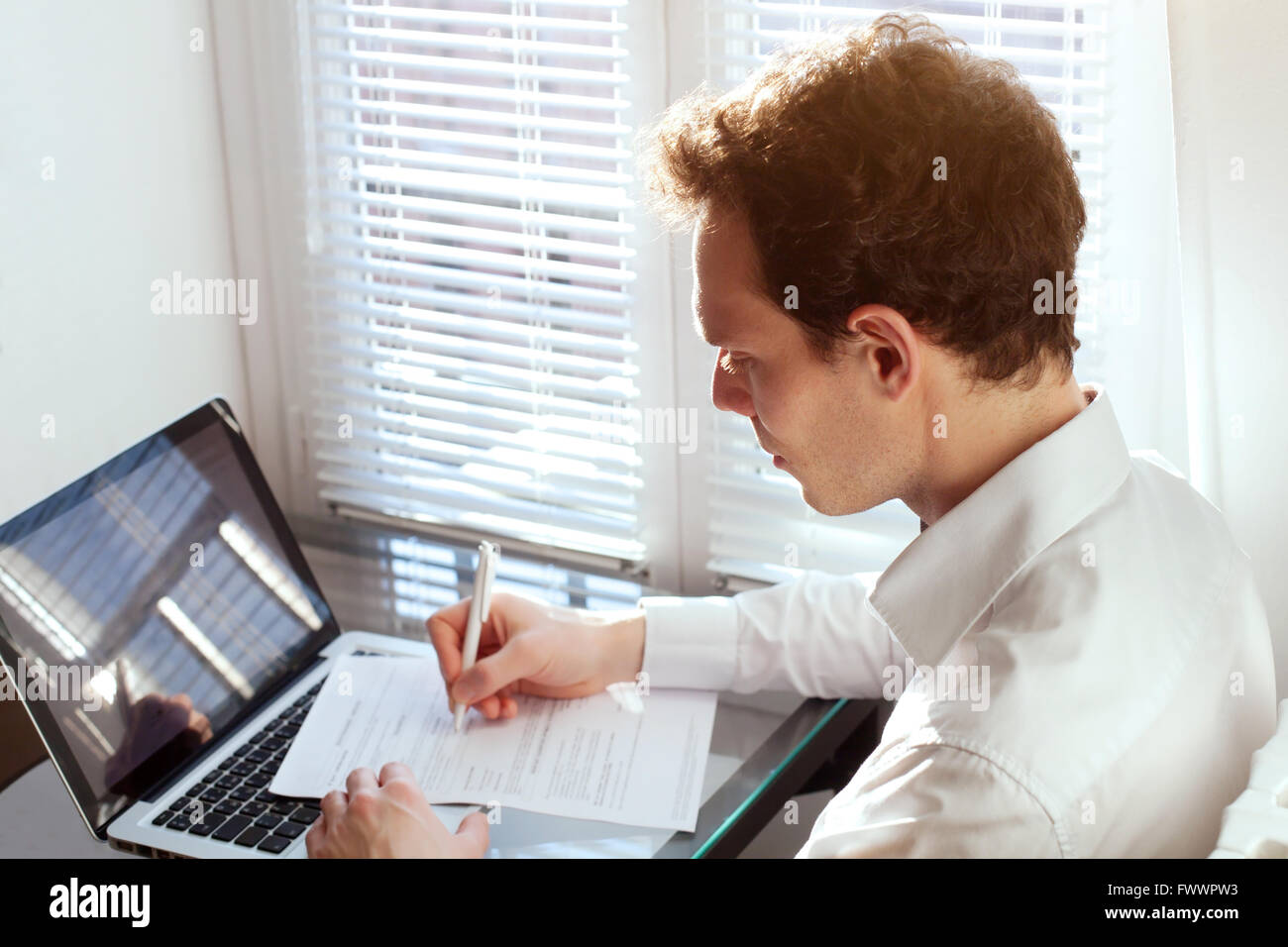 Geschäftsmann, arbeiten mit Dokumenten, Vertrag oder Füllung Steuerformular im Büro in der Nähe von Computer lesen Stockfoto