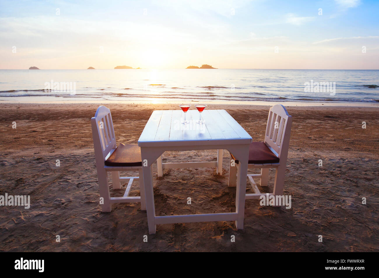 zwei Cocktails in Luxus-Strand-Restaurant bei Sonnenuntergang auf dem Tisch Stockfoto
