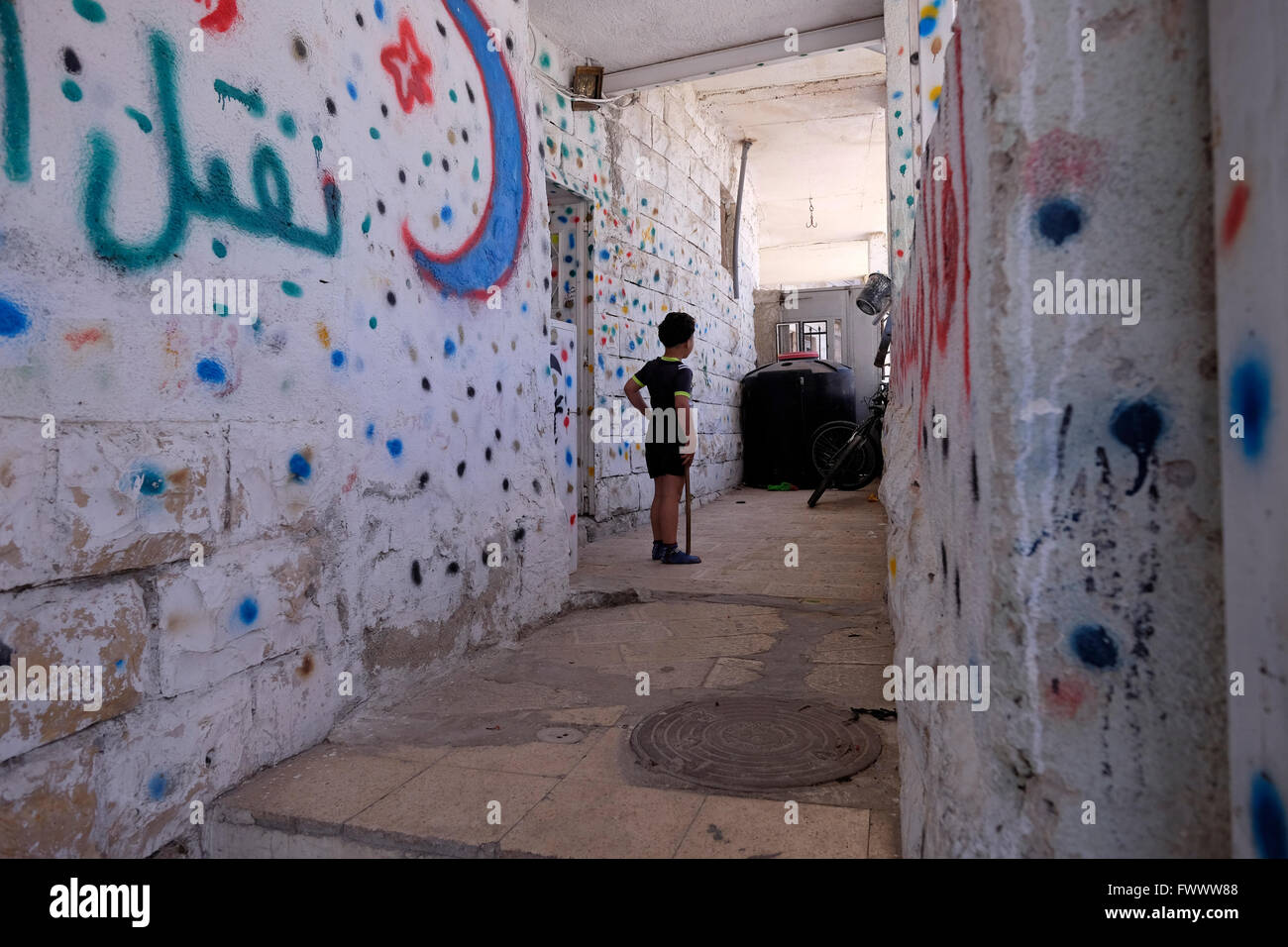 Ein palästinensischer Junge steht am Eingang eines Hauses in der palästinensischen Nachbarschaft Silwan oder Siloam, das sich an den Hängen südlich der Altstadtmauer Ost-Jerusalem Israel befindet Stockfoto