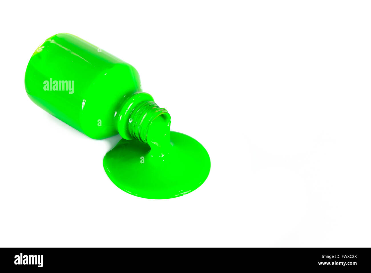 Grüne Farbe, die aus einer Flasche, isoliert auf weiss gießen Stockfoto