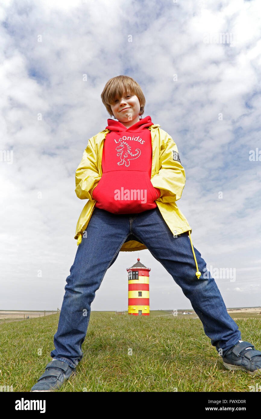 Junge Junge stand Straddle-beinigen vor Pilsum Leuchtturm, Ostfriesland, Niedersachsen, Deutschland Stockfoto