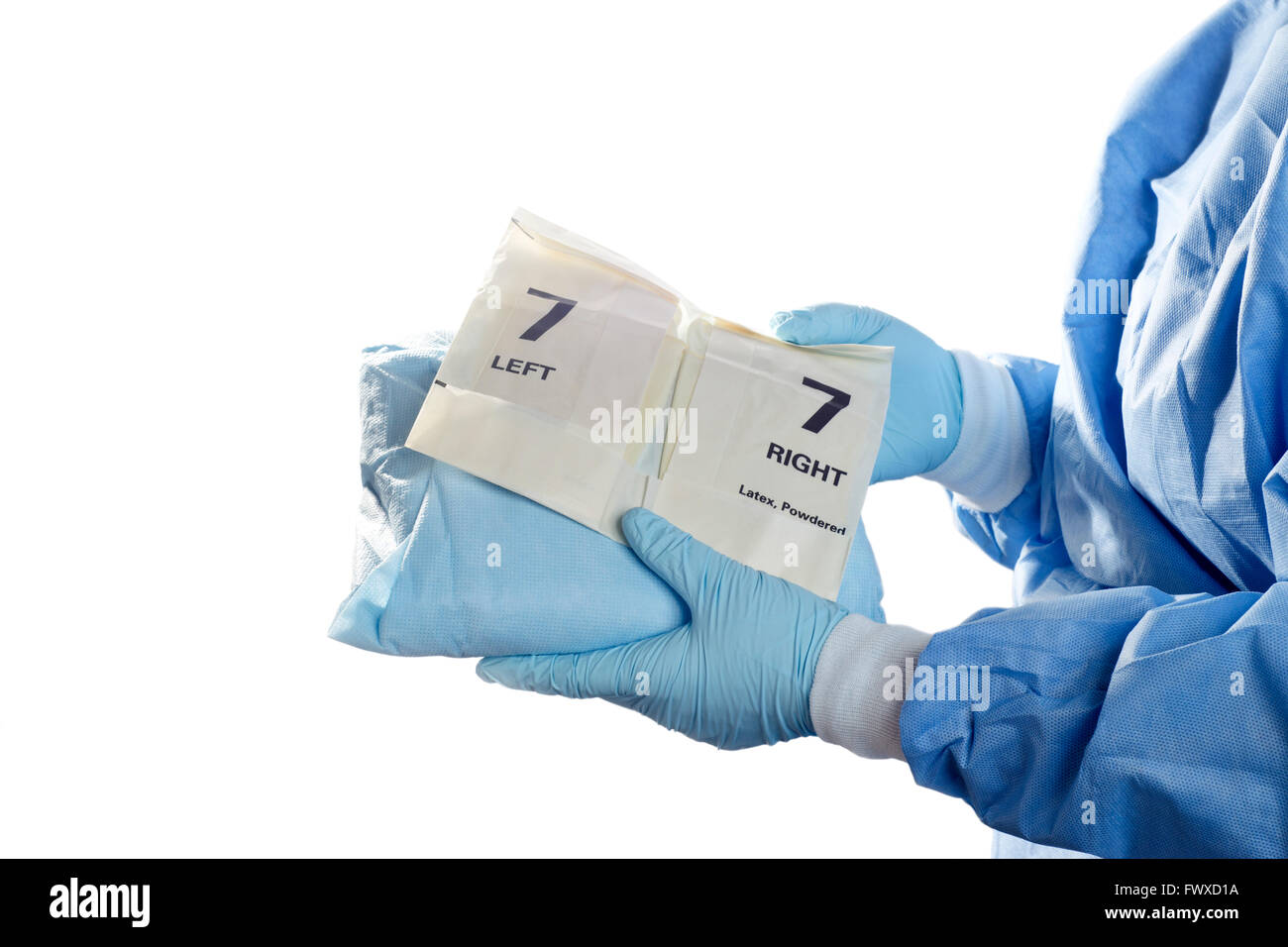 OP-Saal-Techniker hält Kleid und gepuderte Handschuhe für Chirurgen. Stockfoto
