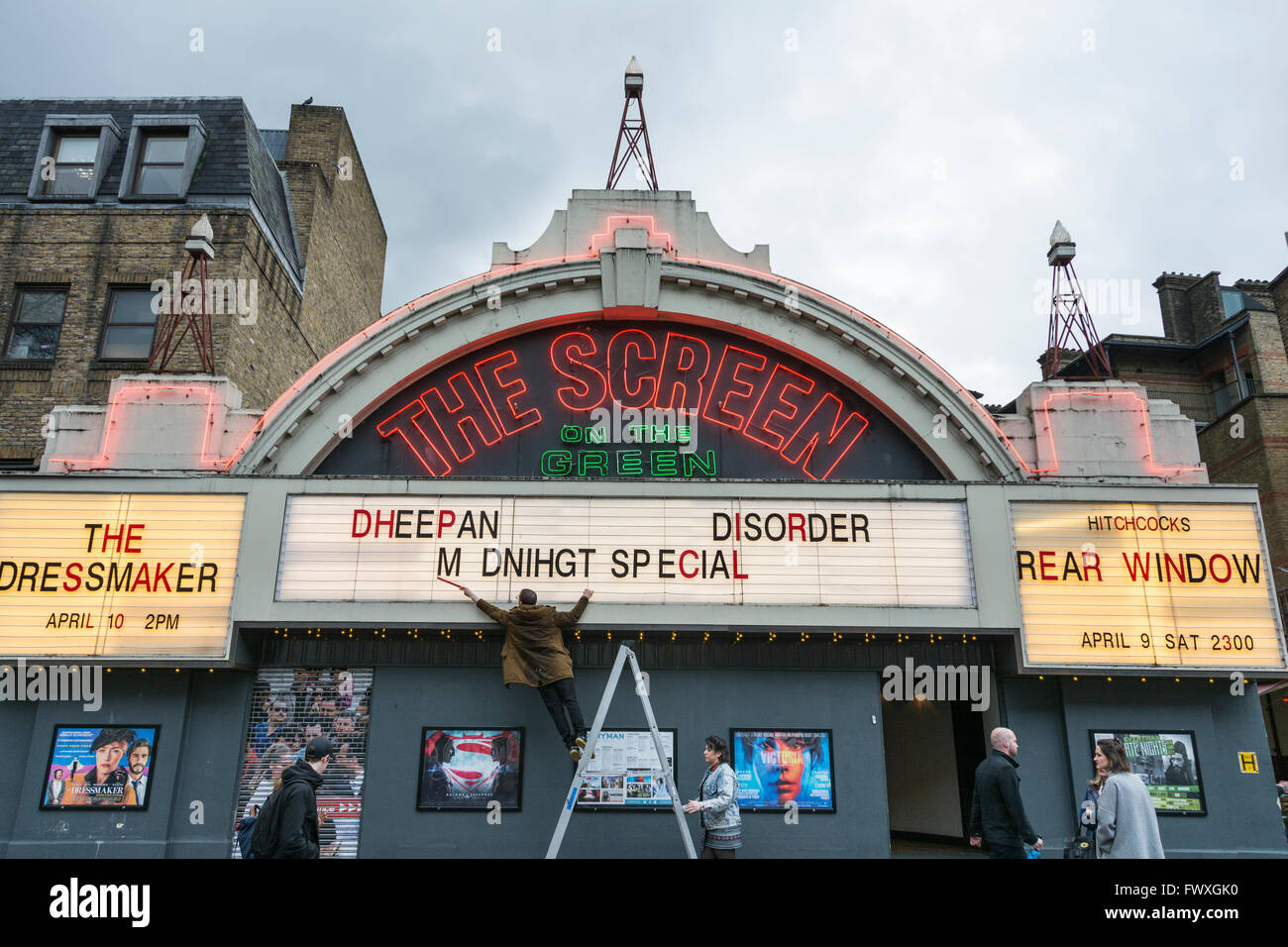 Ein Mann korrigiert die Rechtschreibung auf der Vorderseite des Bildschirms auf die grüne Kino am Upper Street, Islington, London, UK Stockfoto