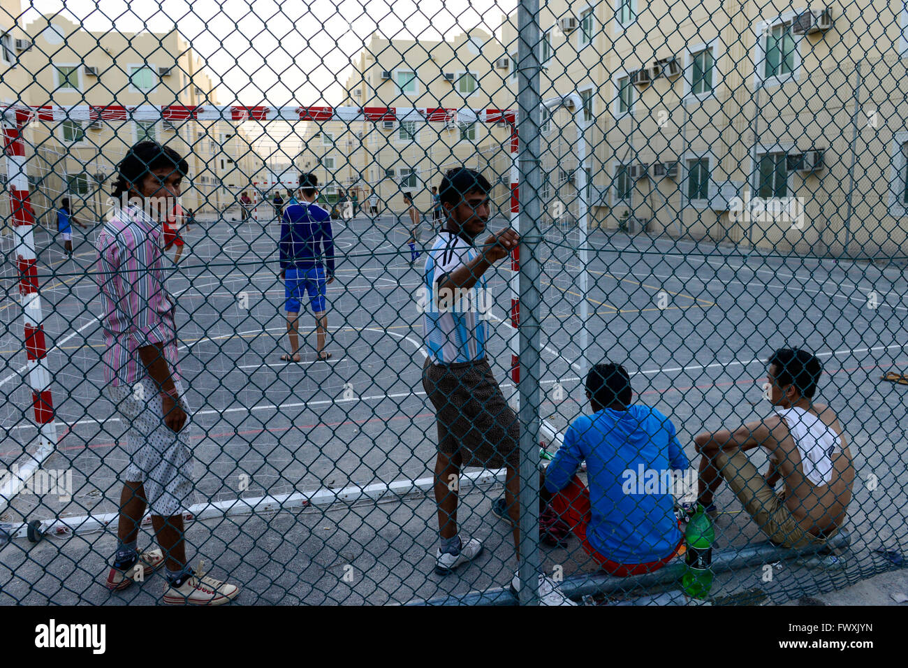 Katar, Doha, industrielle Komplex, Gehäuse Lager für Wanderarbeitnehmer, außerhalb der Stadt, Sport, Arbeitnehmer aus Vietnam und den Philippinen spielen Fußball am Sportplatz Stockfoto