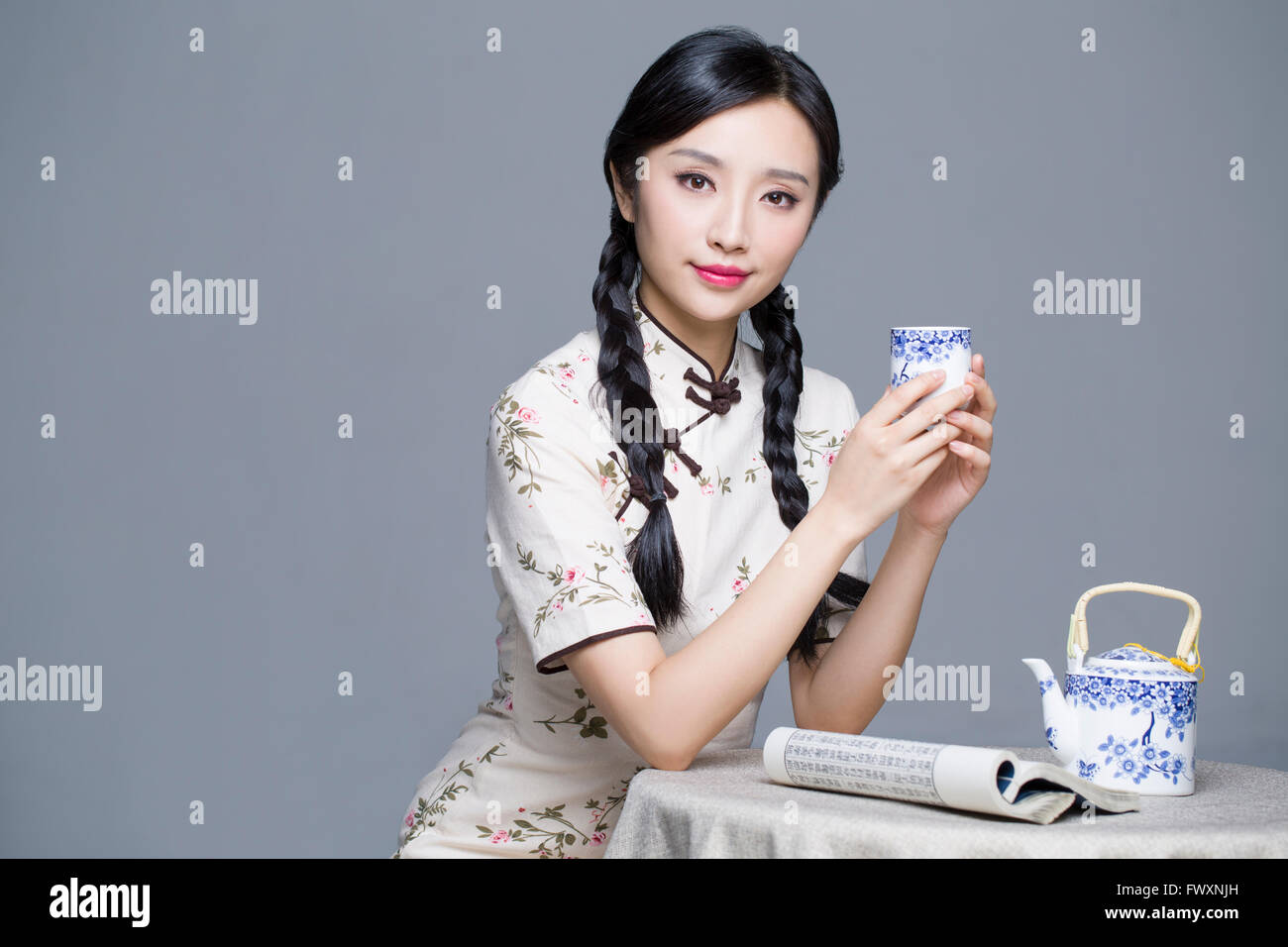 Junge schöne Frau im traditionellen Cheongsam Tee trinken Stockfoto