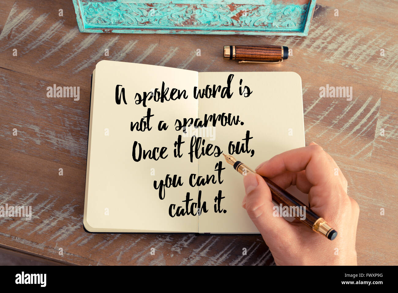 Retro-Effekt und getönten Bild einer Frau hand auf einem Notebook zu schreiben. Handschriftliche Zitat ist ein gesprochenes Wort kein Spatz. Sobald es heraus fliegt, kann nicht es als inspirierende Konzept Bild fangen Stockfoto