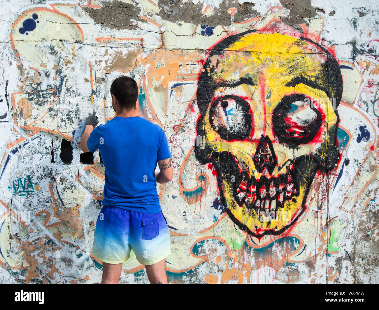 Graffitikünstler sprühen über alte Graffiti an der Wand in Spanien Stockfoto