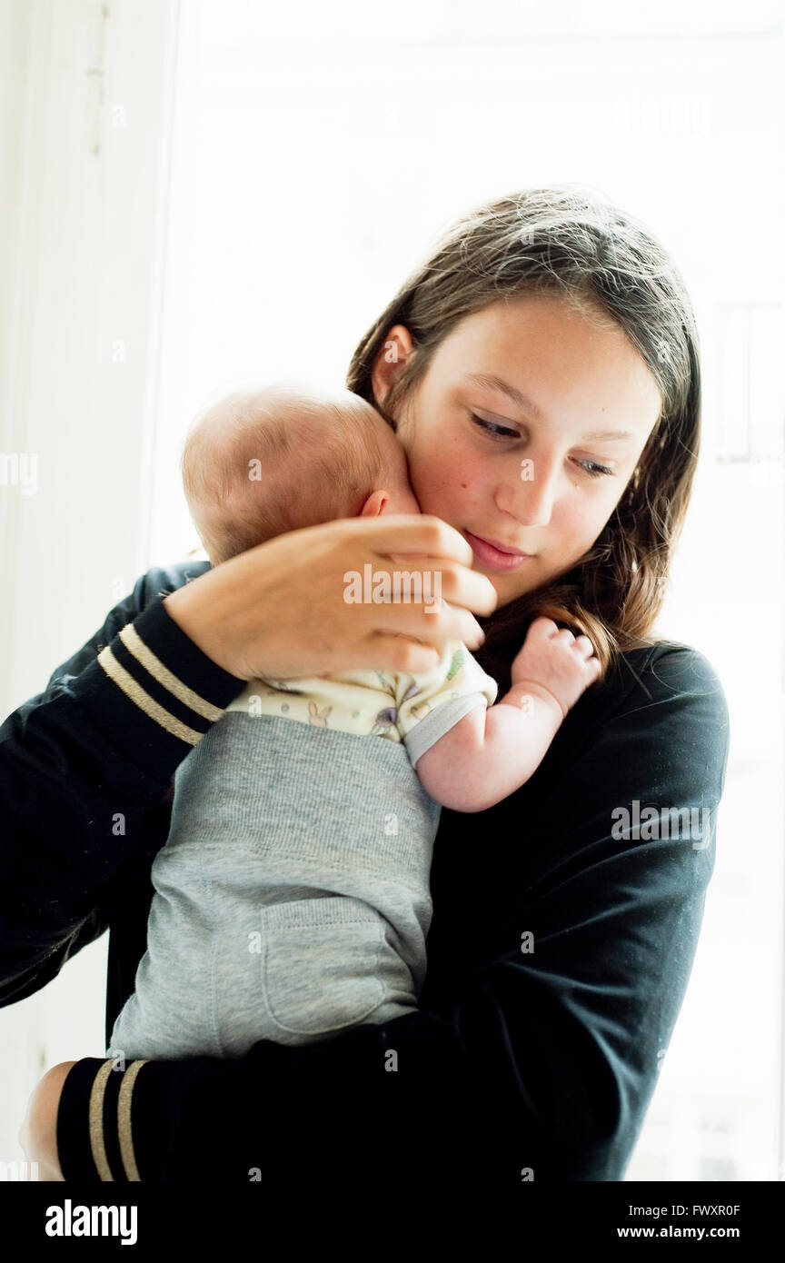 Schweden, Teenage Girl (16-17) halten kleine Babyschwester (2-5 Monate) Stockfoto