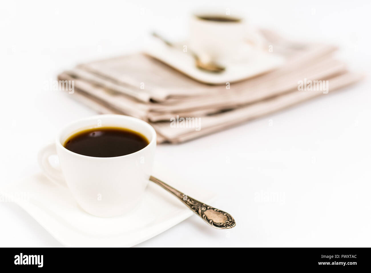 Zeitung und weißen Tasse Kaffee auf weißem Hintergrund Stockfoto