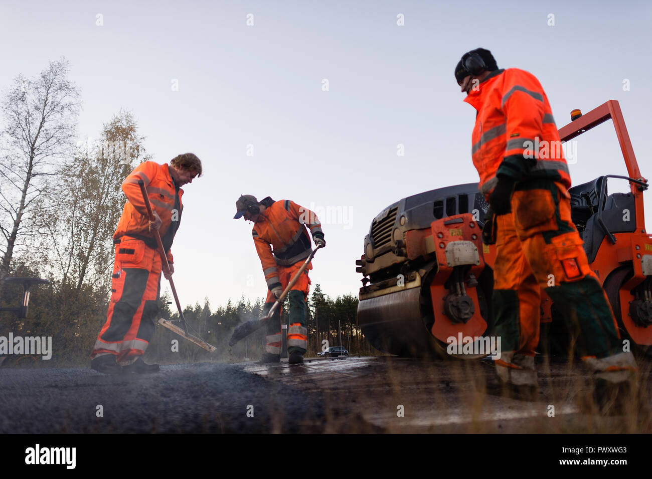 Schweden, Närke, drei Arbeiter, die Straße zu reparieren Stockfoto