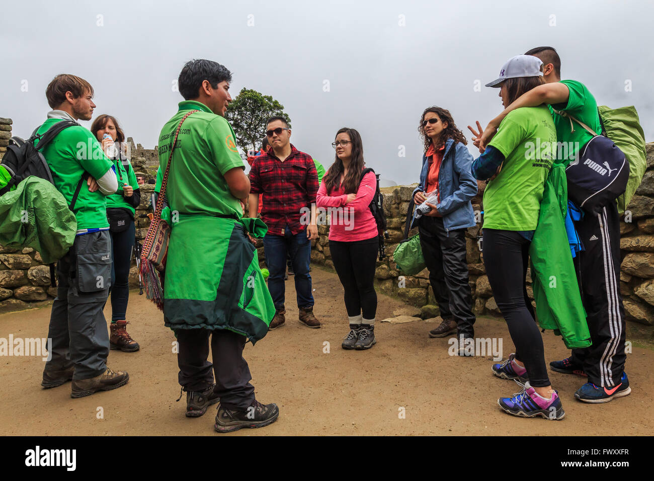 Eine Gruppe von Touristen mit einheimischen Führer erkunden Sie die alten Ruinen von Machu Picchu, Cuzco, Peru Stockfoto