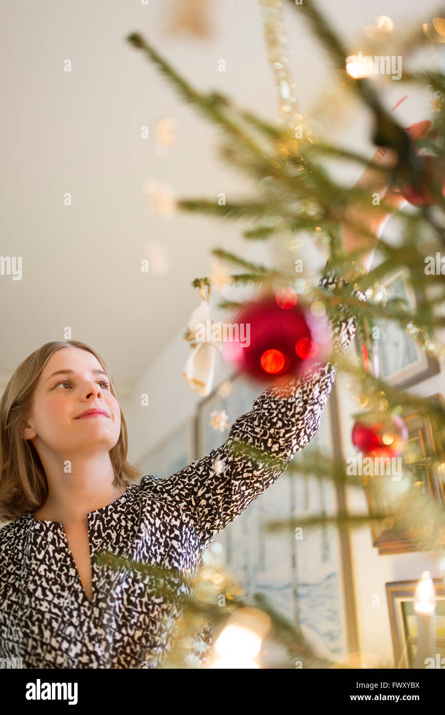 Finnland, junge Frau schmücken Weihnachtsbaum Stockfoto