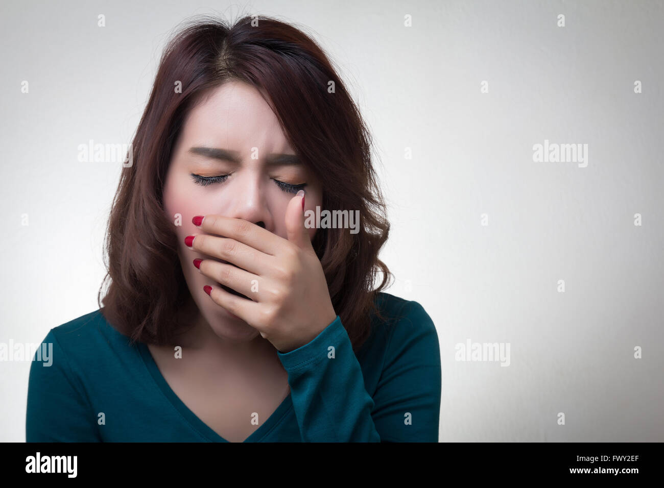 schöne asiatische junge Frau legte Hand über Mund Gähnen Stockfoto