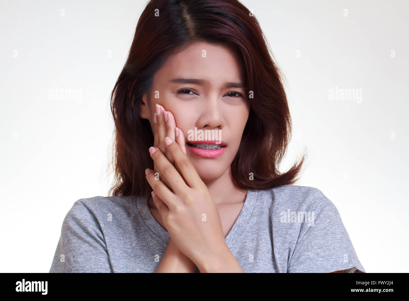Teen Frau gequetscht Wange mit schmerzlichem Gesicht drücken, als ob sie eine schreckliche Zahnschmerzen hat. Stockfoto