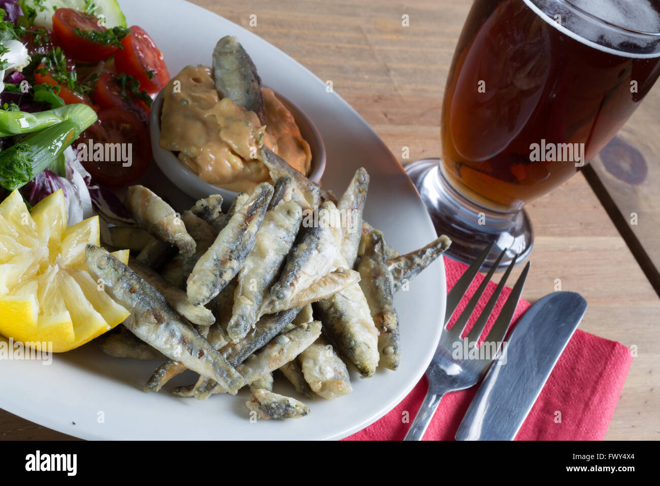 Eine Vorspeise Teller aus einem englischen Pub/Bar-Menü gebratene Sardellen und Marie Rose sauce mit einem Beilagensalat und Glas Bier/Bier. Stockfoto