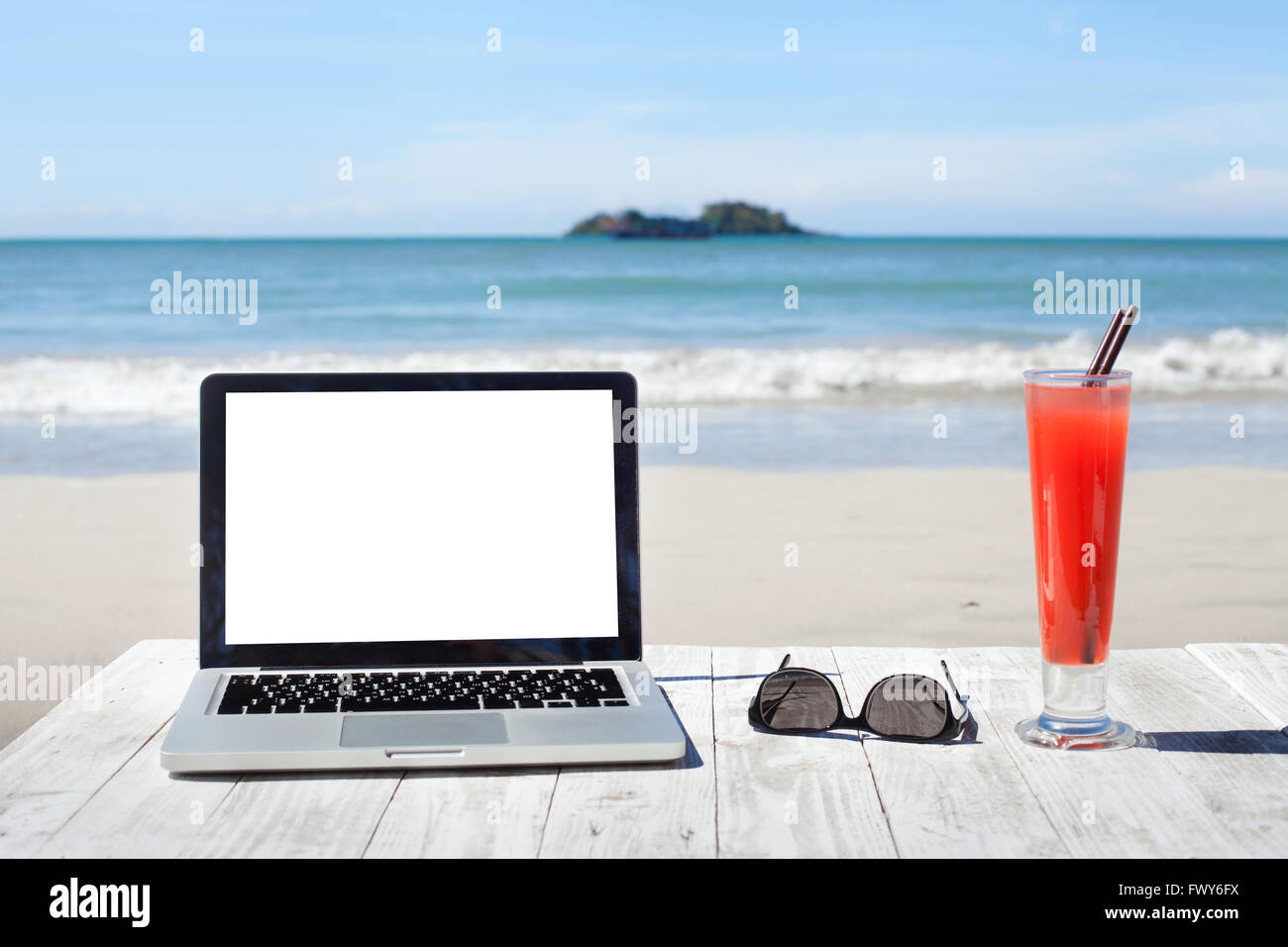 Büro am Strand, Laptop mit leeren Bildschirm, Sonnenbrille und tropischen cocktail Stockfoto