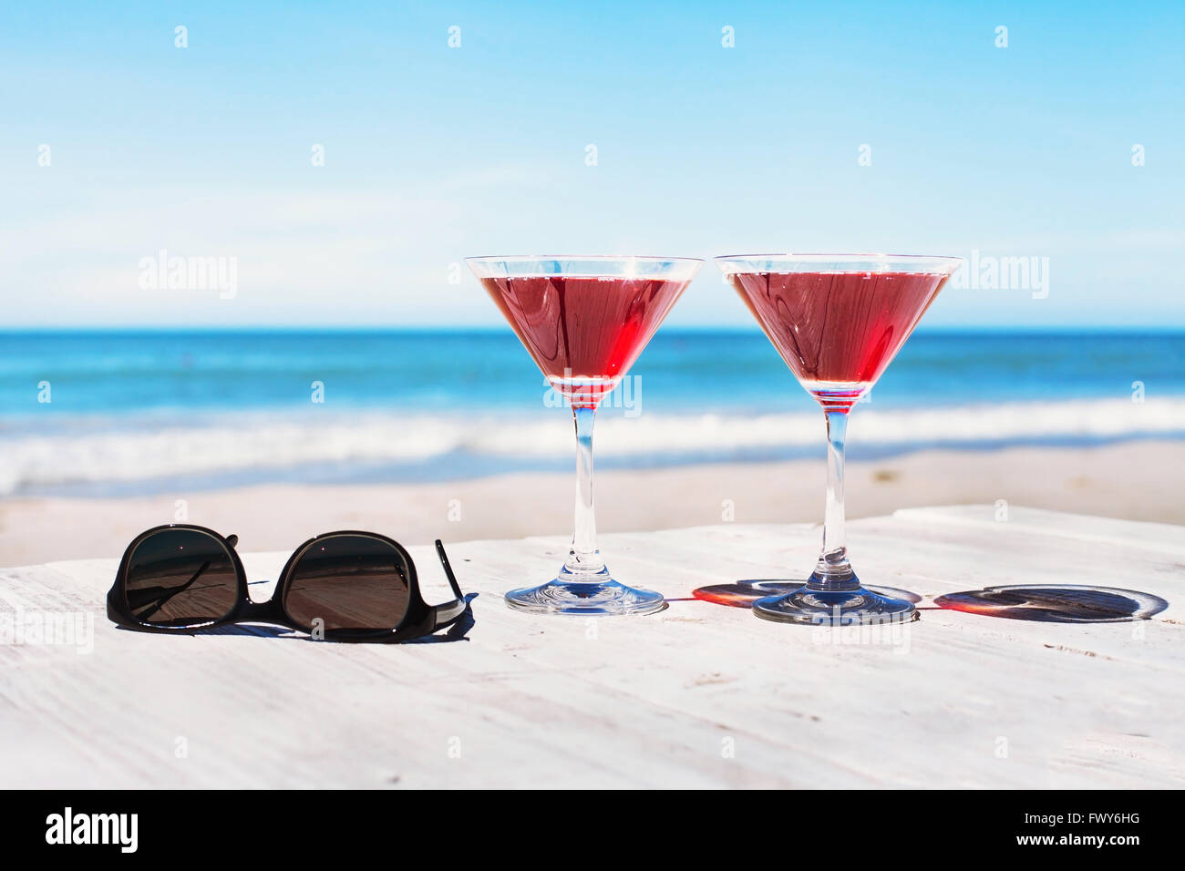 Sommer-Ferien-Konzept, zwei Cocktails und Sonnenbrillen auf dem Strand Tisch, tropischen Urlaub Stockfoto