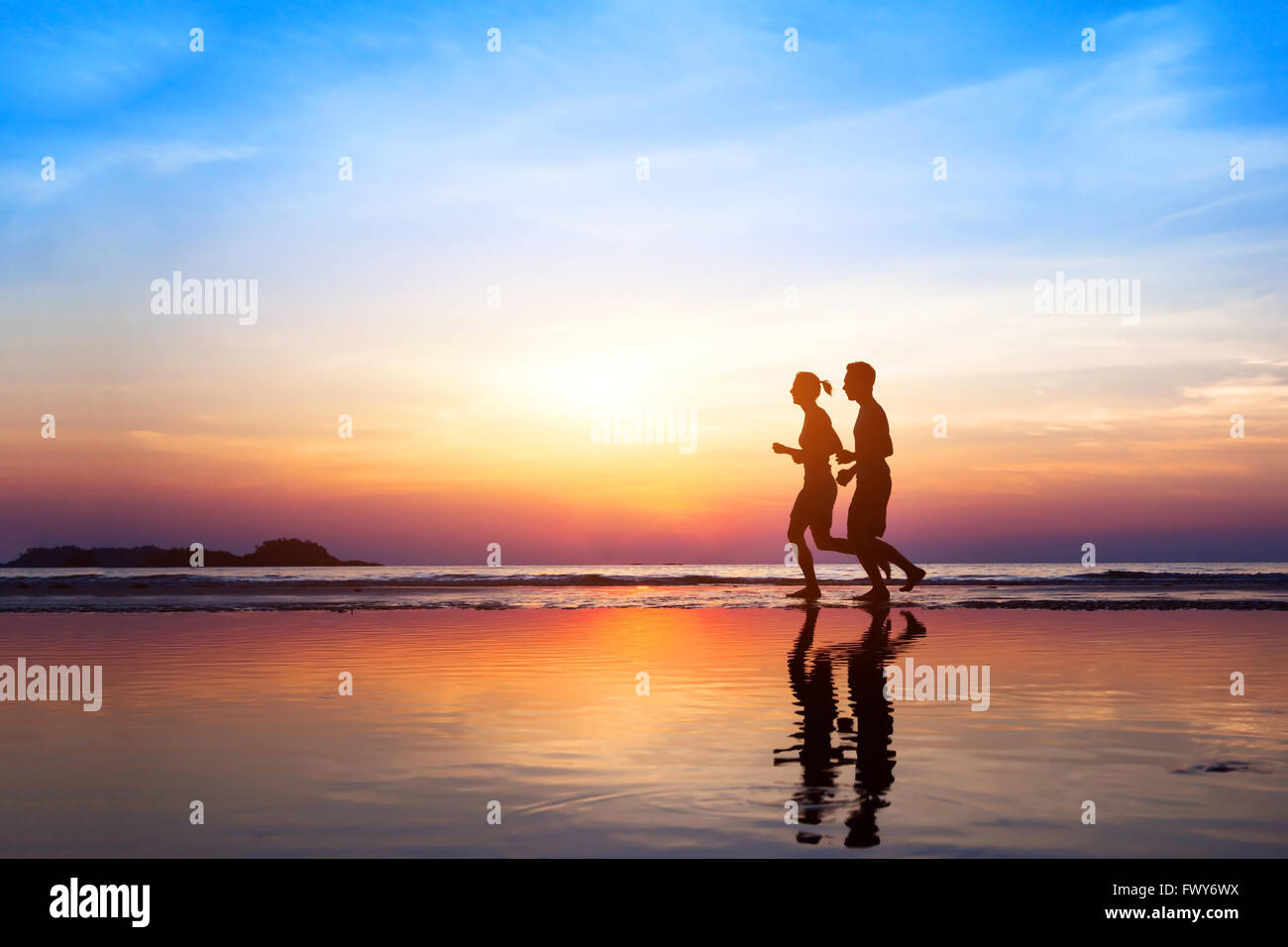 Training-Hintergrund, zwei Menschen, Joggen am Strand bei Sonnenuntergang, Läufer Silhouetten, gesunden Lebensstil-Konzept Stockfoto