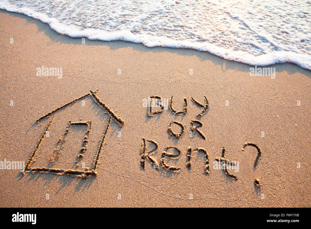 Konzept, Text auf dem Sand, Immobilien mieten oder kaufen Stockfoto