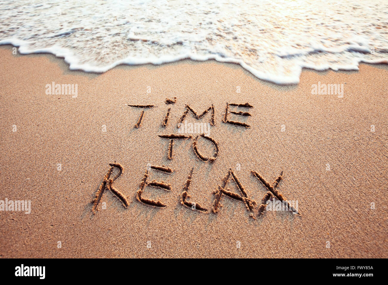 Zeit zum entspannen, Konzept geschrieben am Sandstrand Stockfotografie