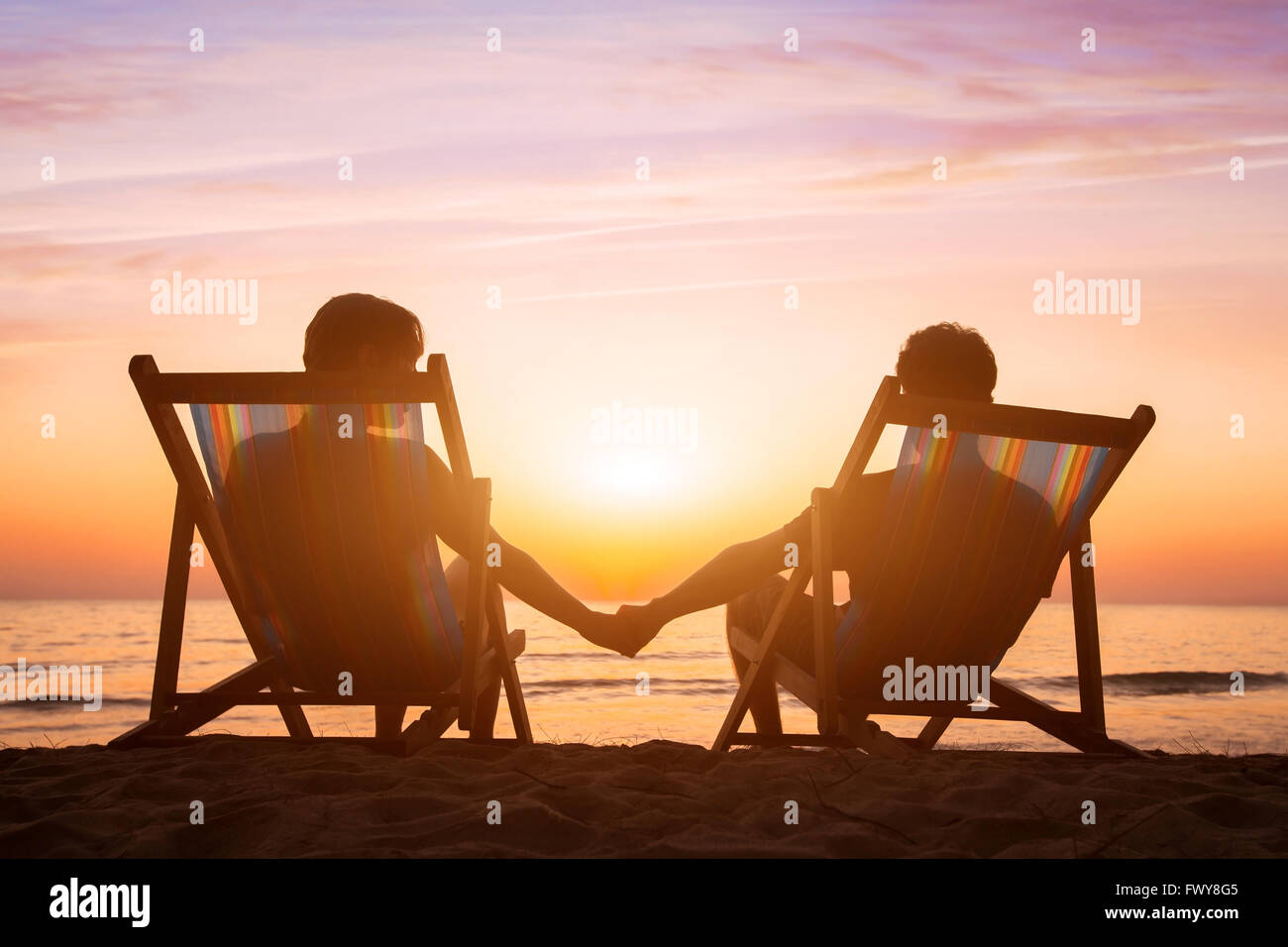 romantische Liebe Hintergrund, Flitterwochen, paar entspannend am Strand bei Sonnenuntergang Stockfoto