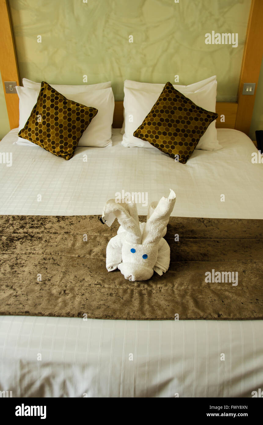 Weiß braun Schlafzimmer mit weißem Plüsch-Spielzeug auf den braunen Bettdecke. Stockfoto