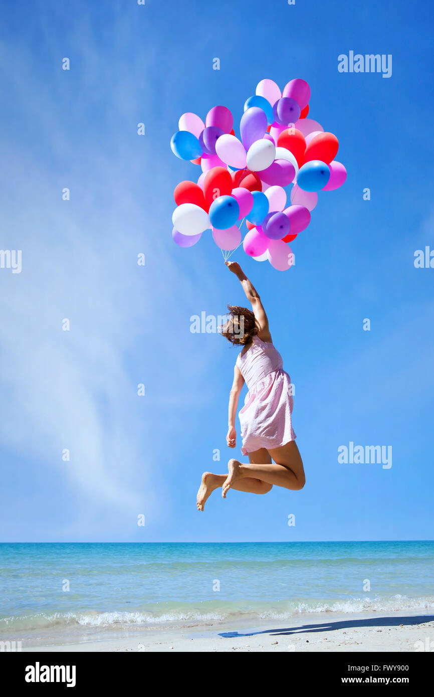Inspiration, glückliche Menschen, Frau fliegen mit bunten Luftballons in den blauen Himmel, kreatives Konzept Stockfoto