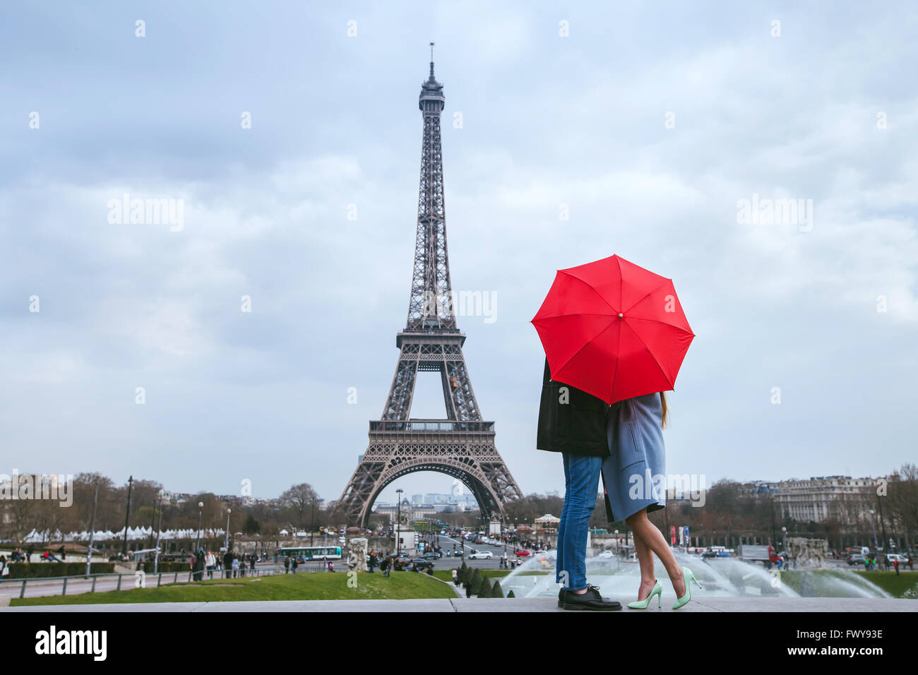 Flitterwochen Sie in Paris, paar küssen hinter roten Regenschirm gegen Eiffelturm Stockfoto