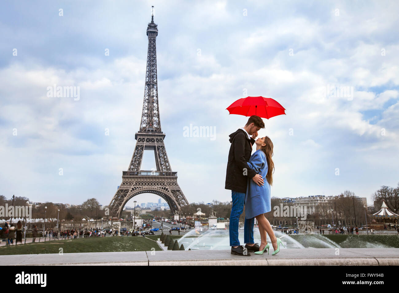 schönes Paar mit Regenschirm in der Nähe von Eiffelturm, Flitterwochen in Paris, romantische Momente Stockfoto