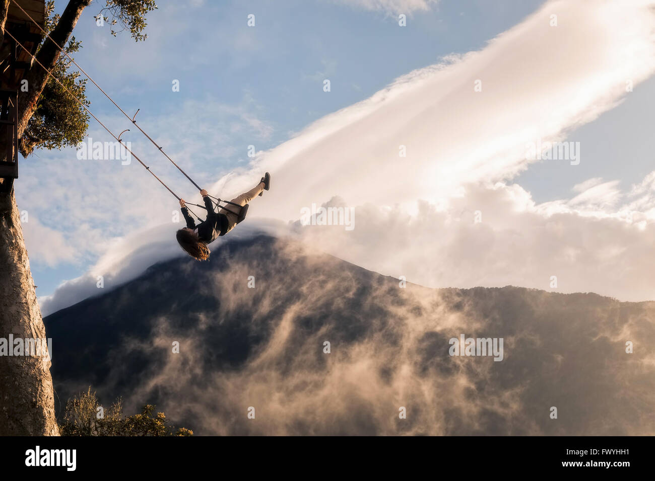 Banos, Ecuador - 25. November 2015: junge Mädchen, die eine Fahrt auf dem hohen Seil fliegen hängt an einem Baum-Haus Stockfoto