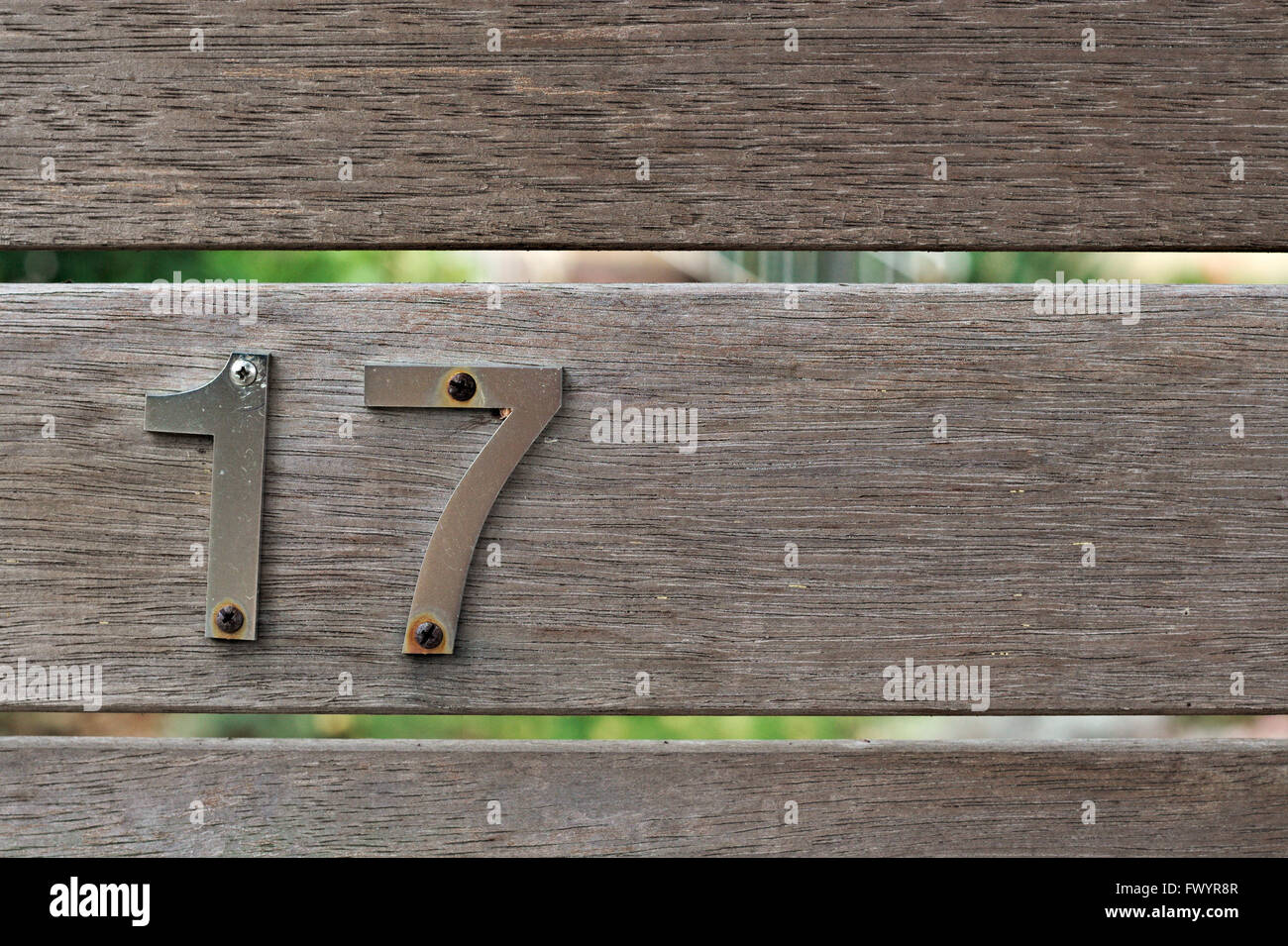 Metall-Nummer 17 auf eine unbemalte Holzzaun geschraubt. Stockfoto