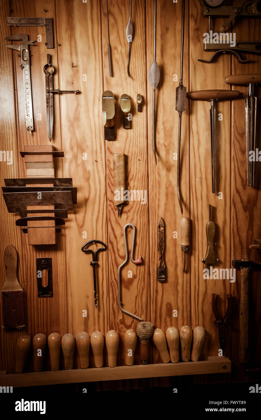 Viele verschiedene alte Tools hängen an der Wand Stockfoto