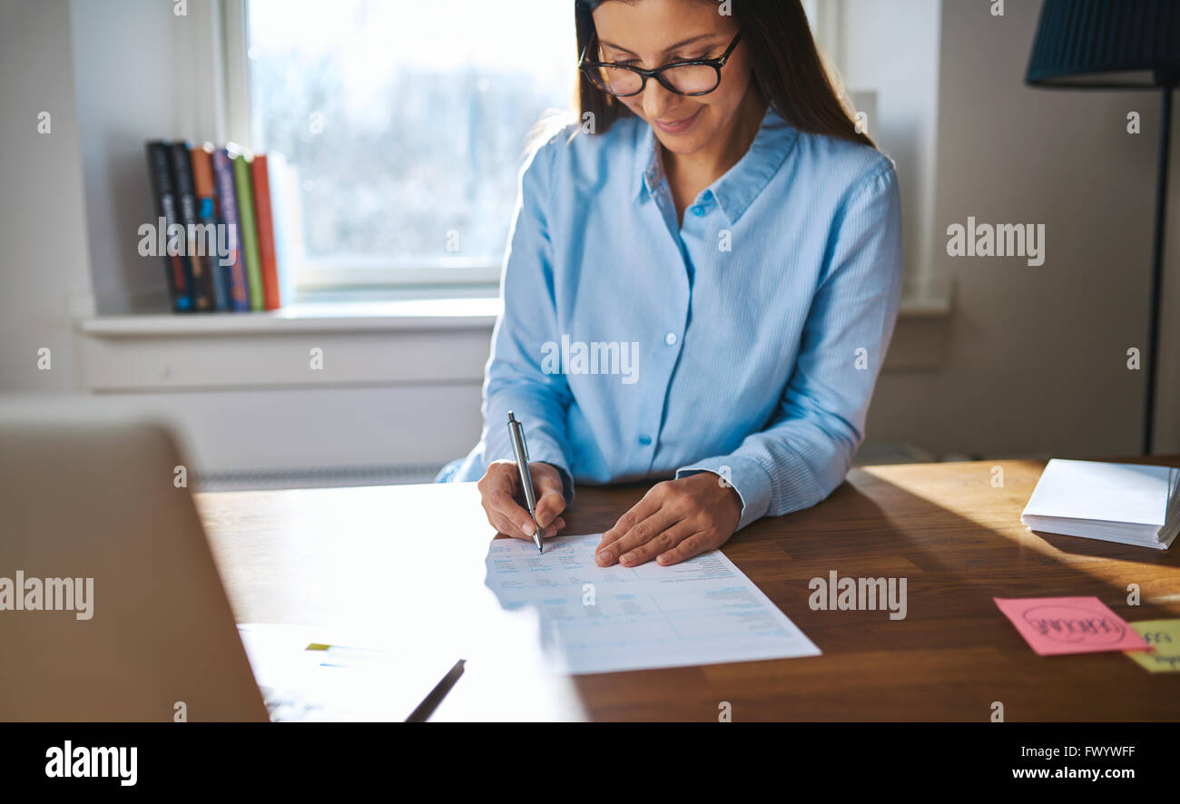 Erfolgreiche Unternehmerin oder Inhaber eines kleinen Unternehmens arbeiten an ihrem Schreibtisch zu Hause, im Büro, Schreiben von Notizen oder Sining ein Dokum Stockfoto