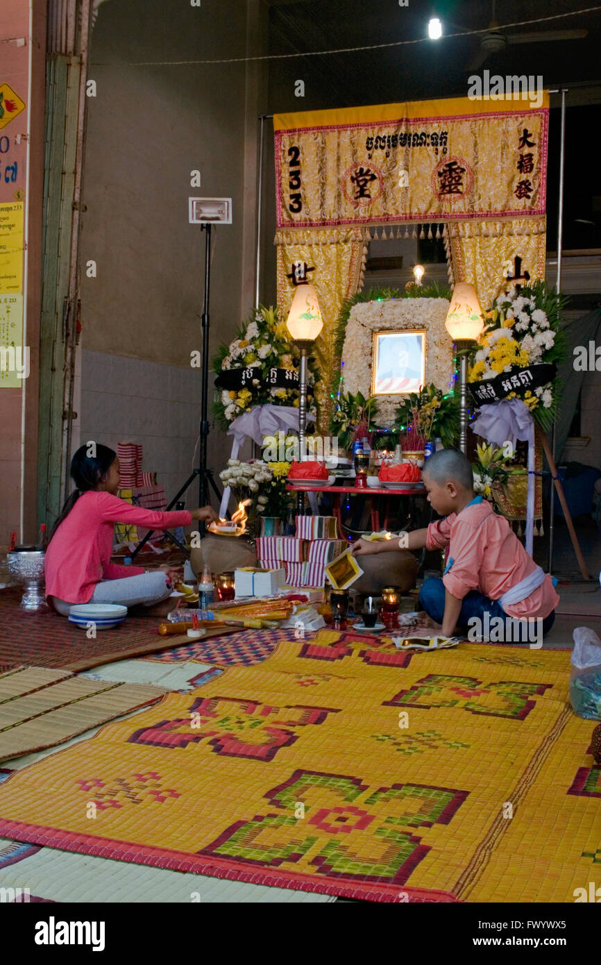 Ein Junge & ein Mädchen sind Zündpapier brennt an einem Altar in einer traditionellen buddhistischen Zeremonie in Ou Reang Ov, Kambodscha. Stockfoto