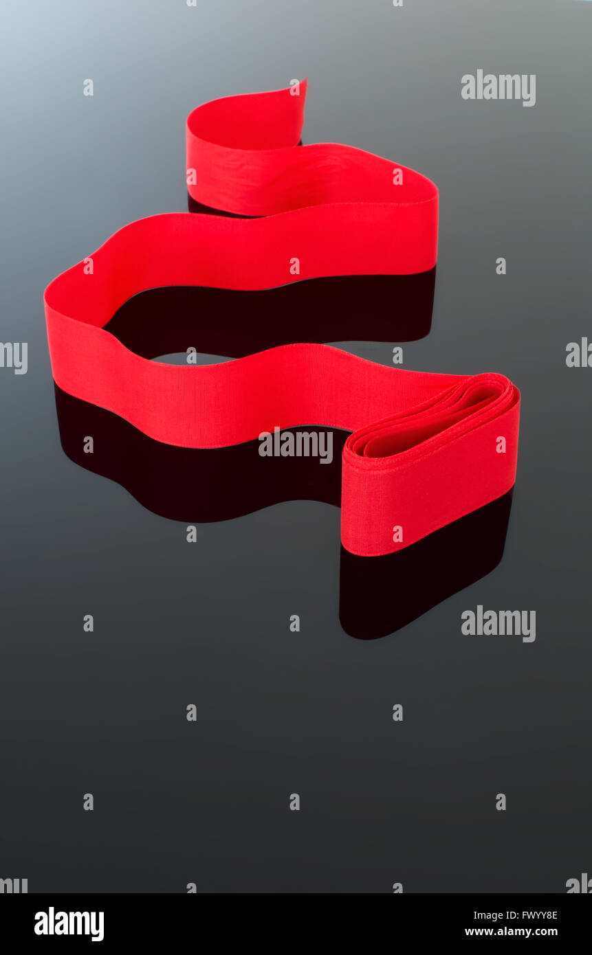 Gewelltes rotes Band isoliert auf schwarz weißen schrittweise Hintergrund, elegante Feier Symbol. Stockfoto