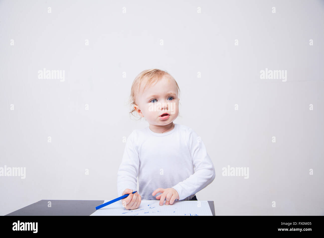 Babymädchen zeichnen mit bunten Filzstiften auf weißem Hintergrund Stockfoto