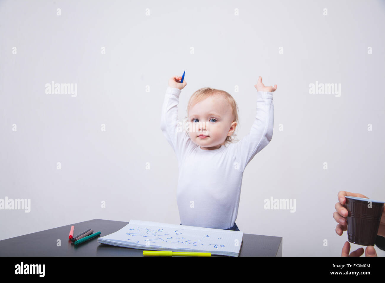 Babymädchen zeichnen mit bunten Filzstiften auf weißem Hintergrund Stockfoto