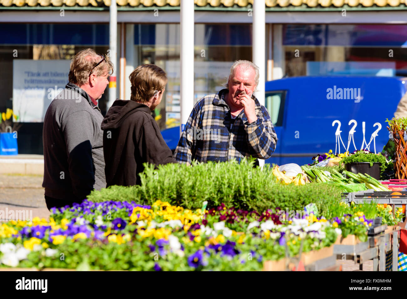 Simrishamn, Schweden - 1. April 2016: Mann ist etwas vom Markt Verkostung als er mit zwei Othermen spricht. Alltagssituation in Stockfoto