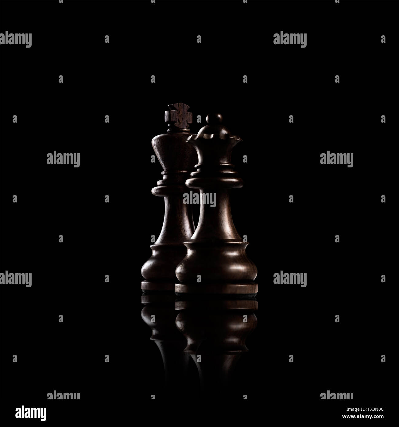 Schach Spiel-Konzept der schwarzen Holz König und die Königin, die mächtigsten Figuren stehen gemeinsam vor einem dunklen Hintergrund. Stockfoto