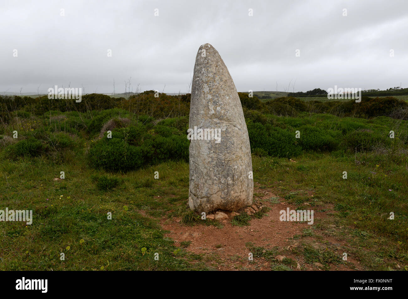 Eine gebogene Menhir präsidiert über die Landschaft der Algarve Stockfoto