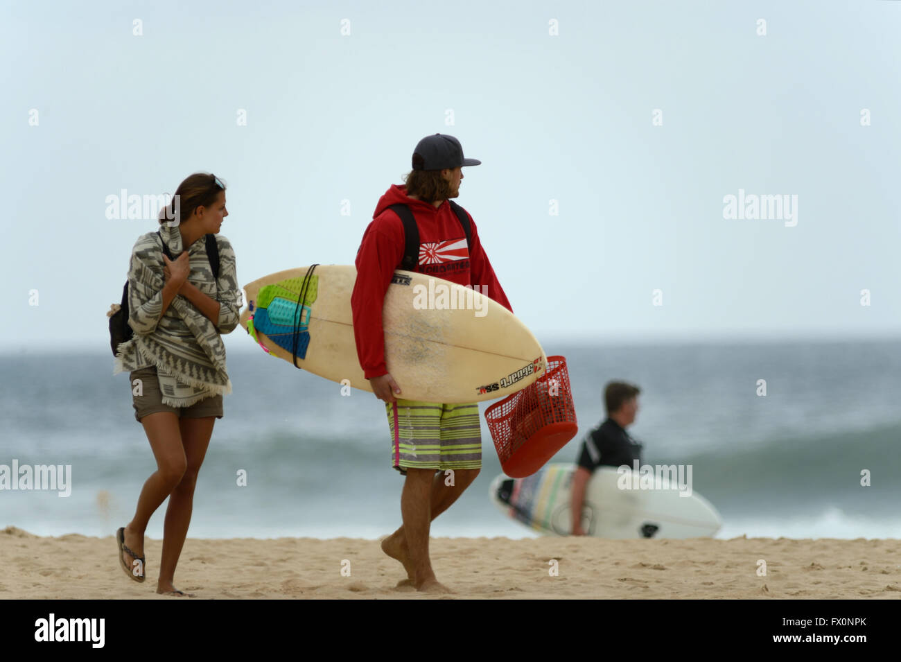 Junges Paar beobachten die Brandung, wie sie Sandsurfen in der Algarve Praia Do Zavial überqueren Stockfoto