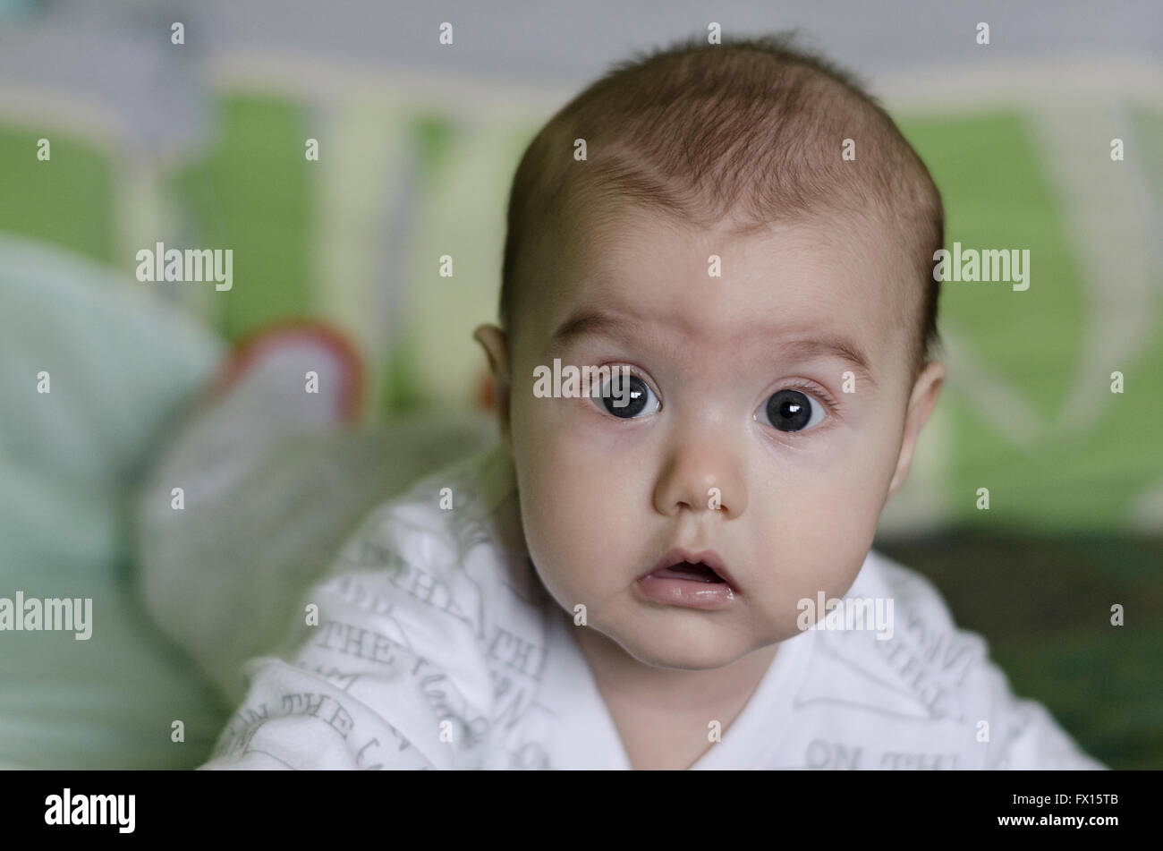 Babymädchen mit blauen Augen lernt zu krabbeln Stockfoto