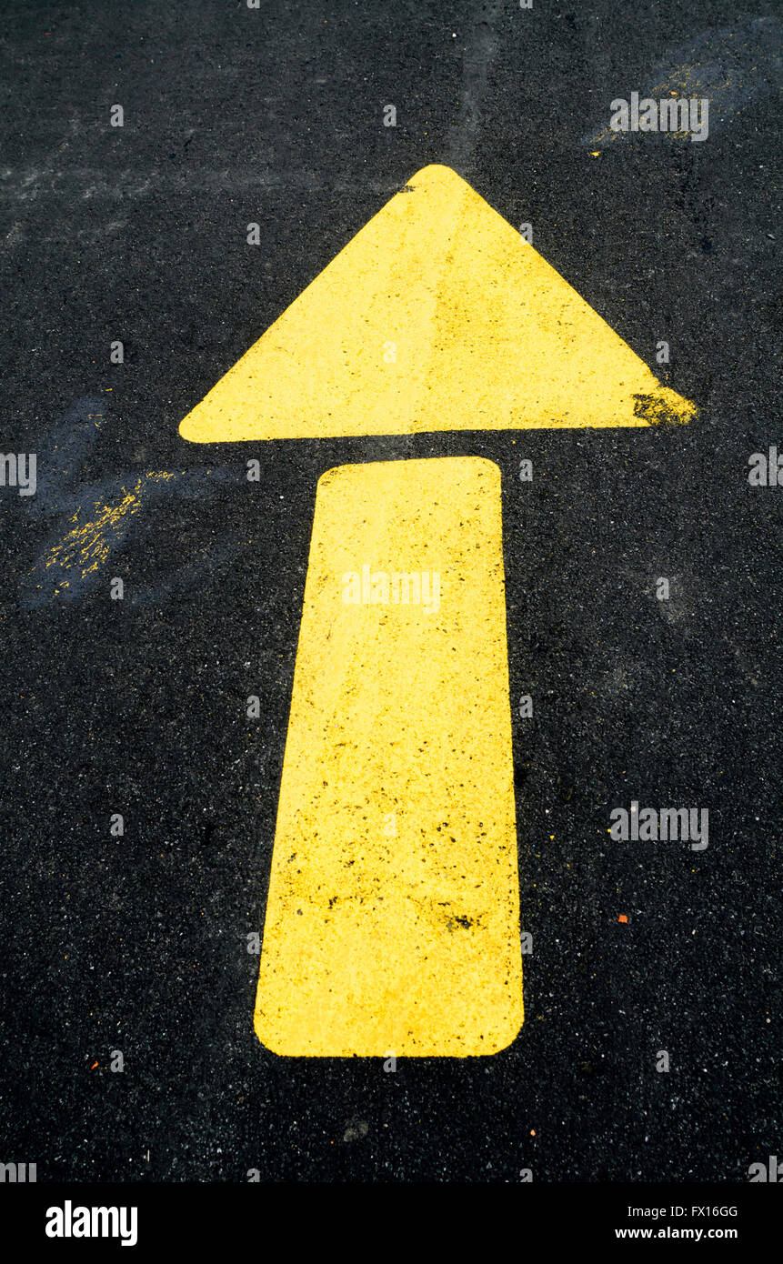 Gelber Pfeil aufgemalt Straße zum direkten Verkehr Stockfoto