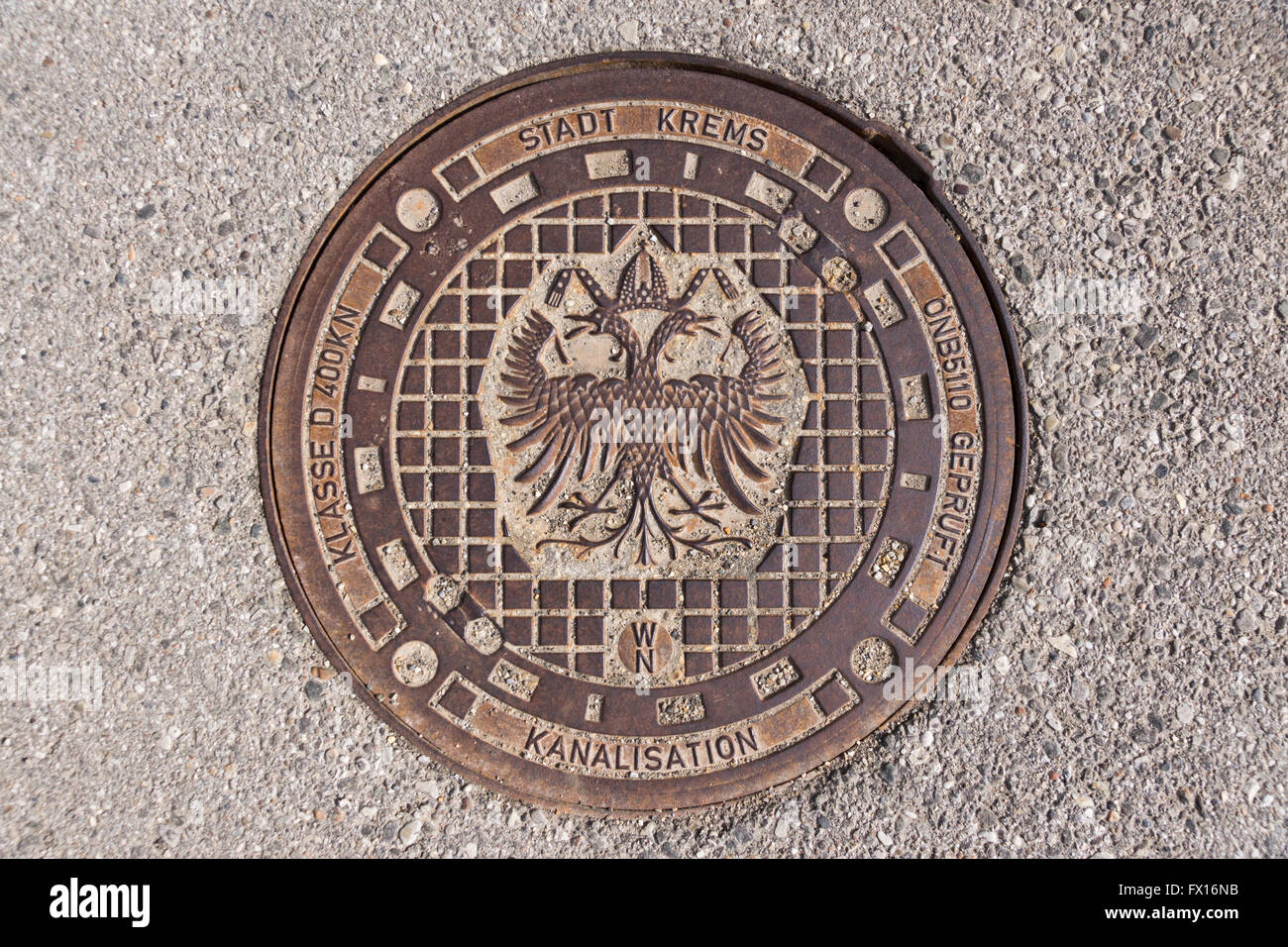 Eine typische Kanaldeckel in der unteren österreichischen Krems zeigt das doppelköpfigen Reichsadler-emblem Stockfoto