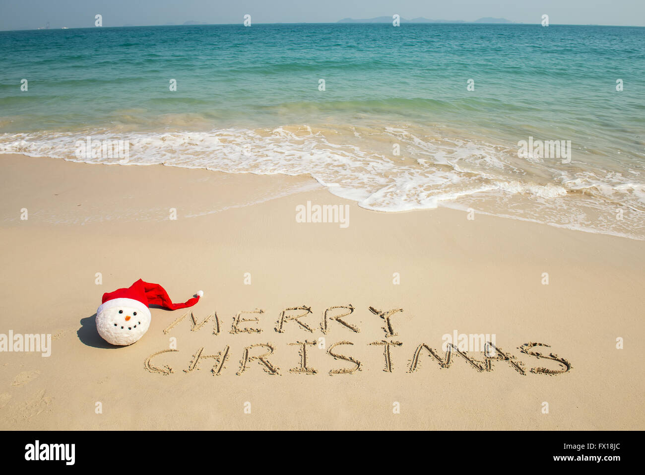 Frohe Weihnachten geschrieben am tropischen Strand weißen Sand mit Weihnachten Schneemann Stockfoto