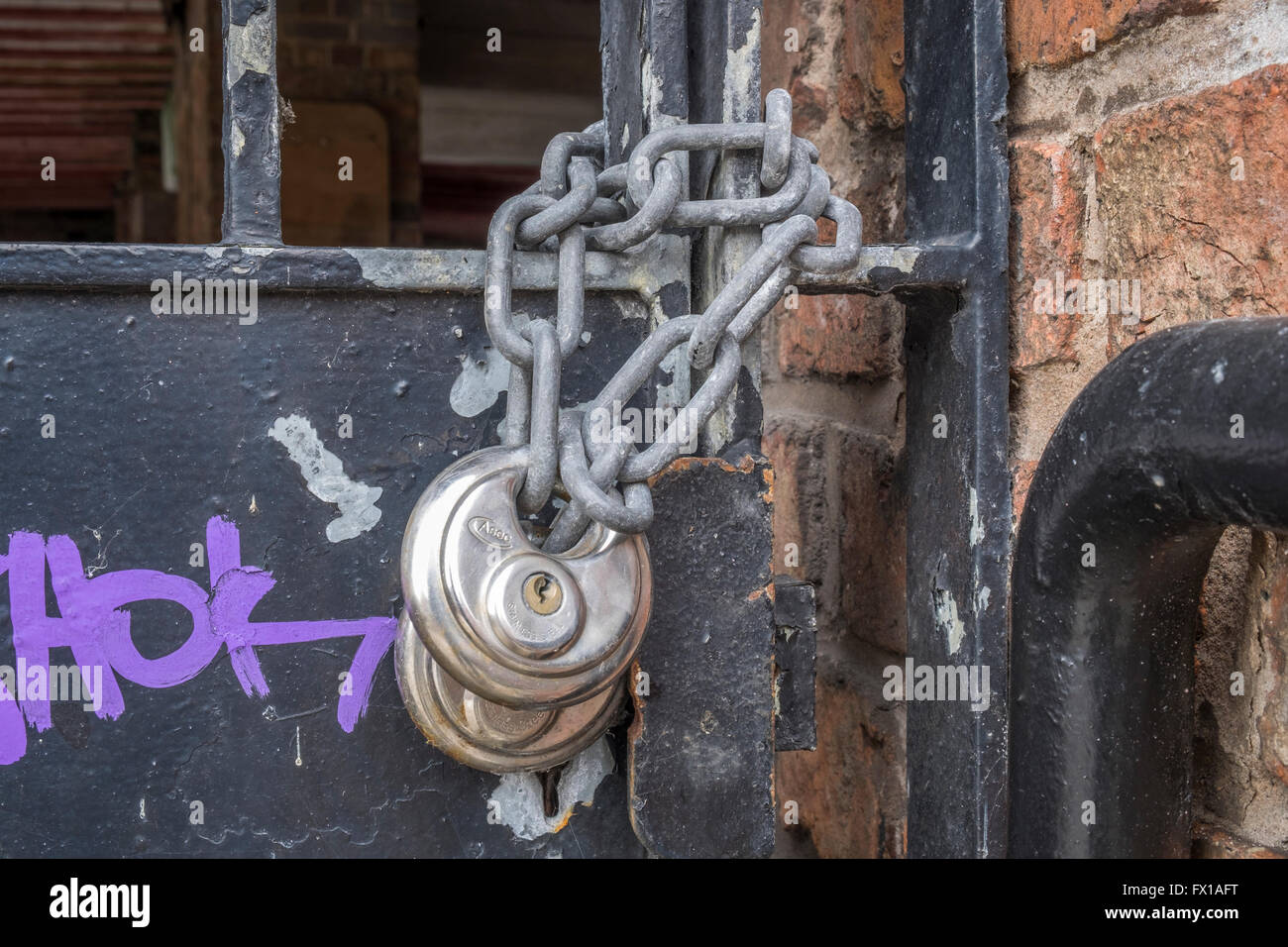 Zwei Vorhängeschlösser und eine einzelne Kette Metall Tor zu sichern Stockfoto