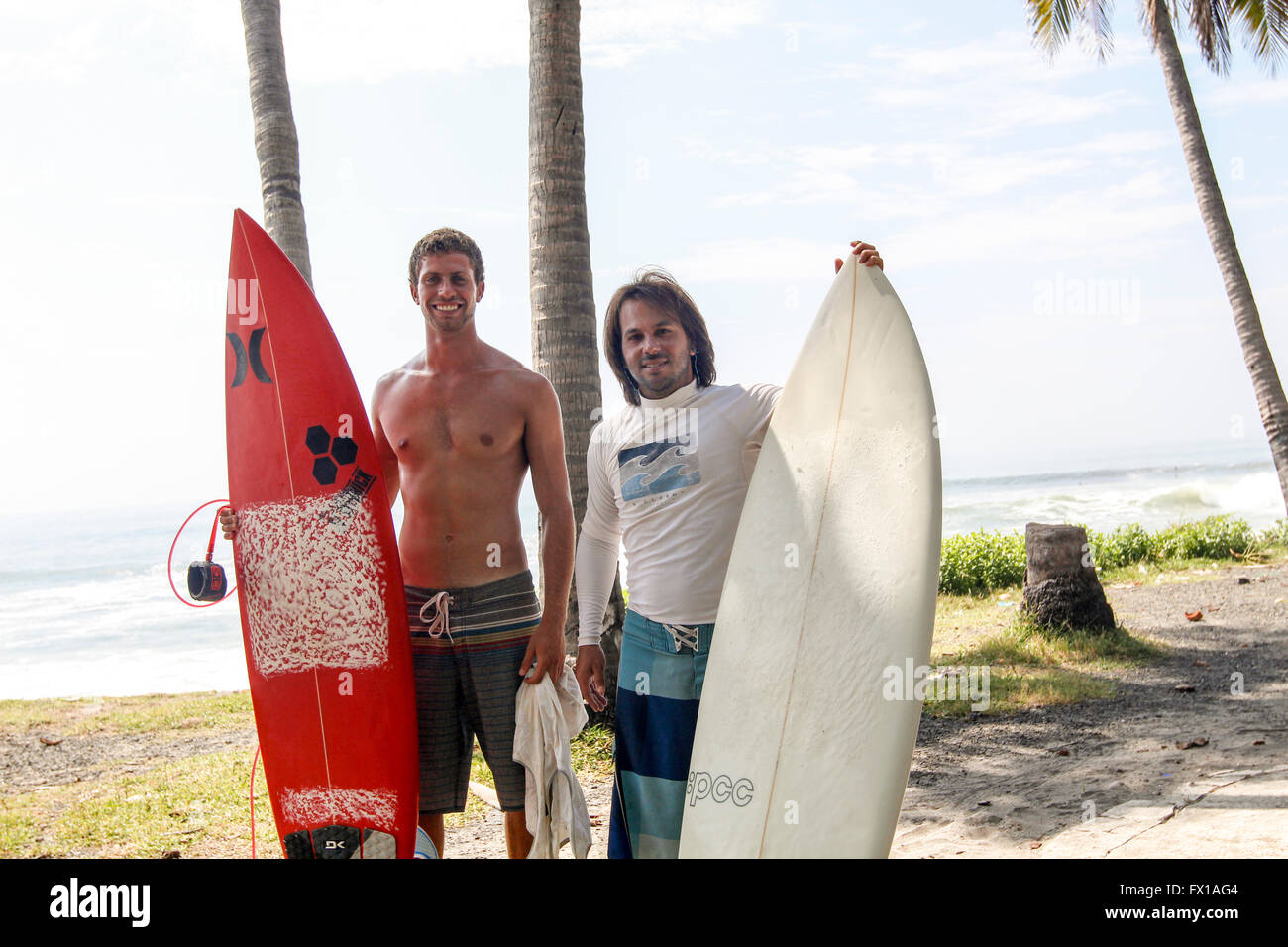 Zwei Surfer mit Surfbrettern fotografiert am Strand von El Tunco, El Salvador Stockfoto