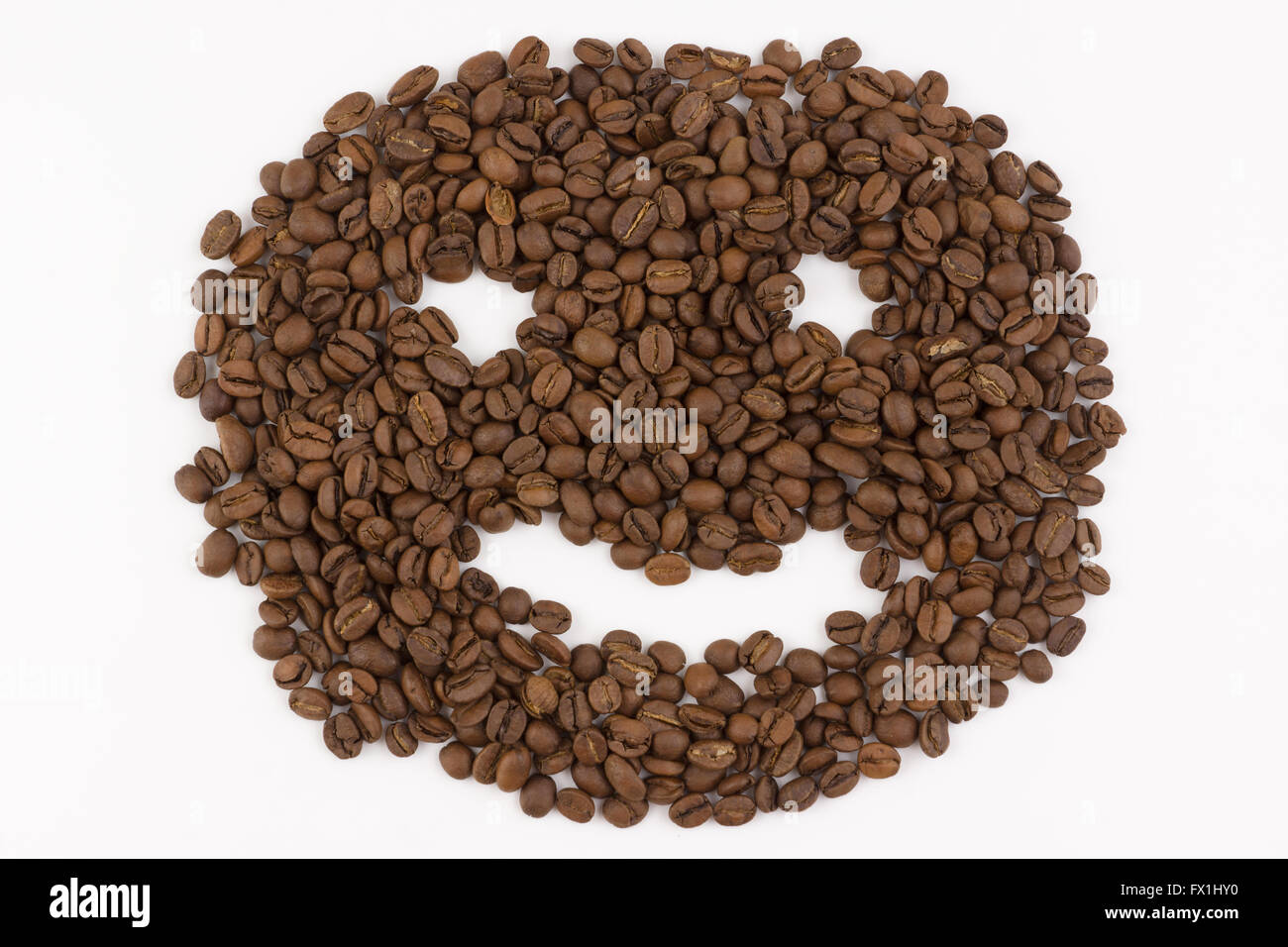 Hill-Kaffeebohnen liegt auf einem weißen Hintergrund in Form von Gesicht Stockfoto
