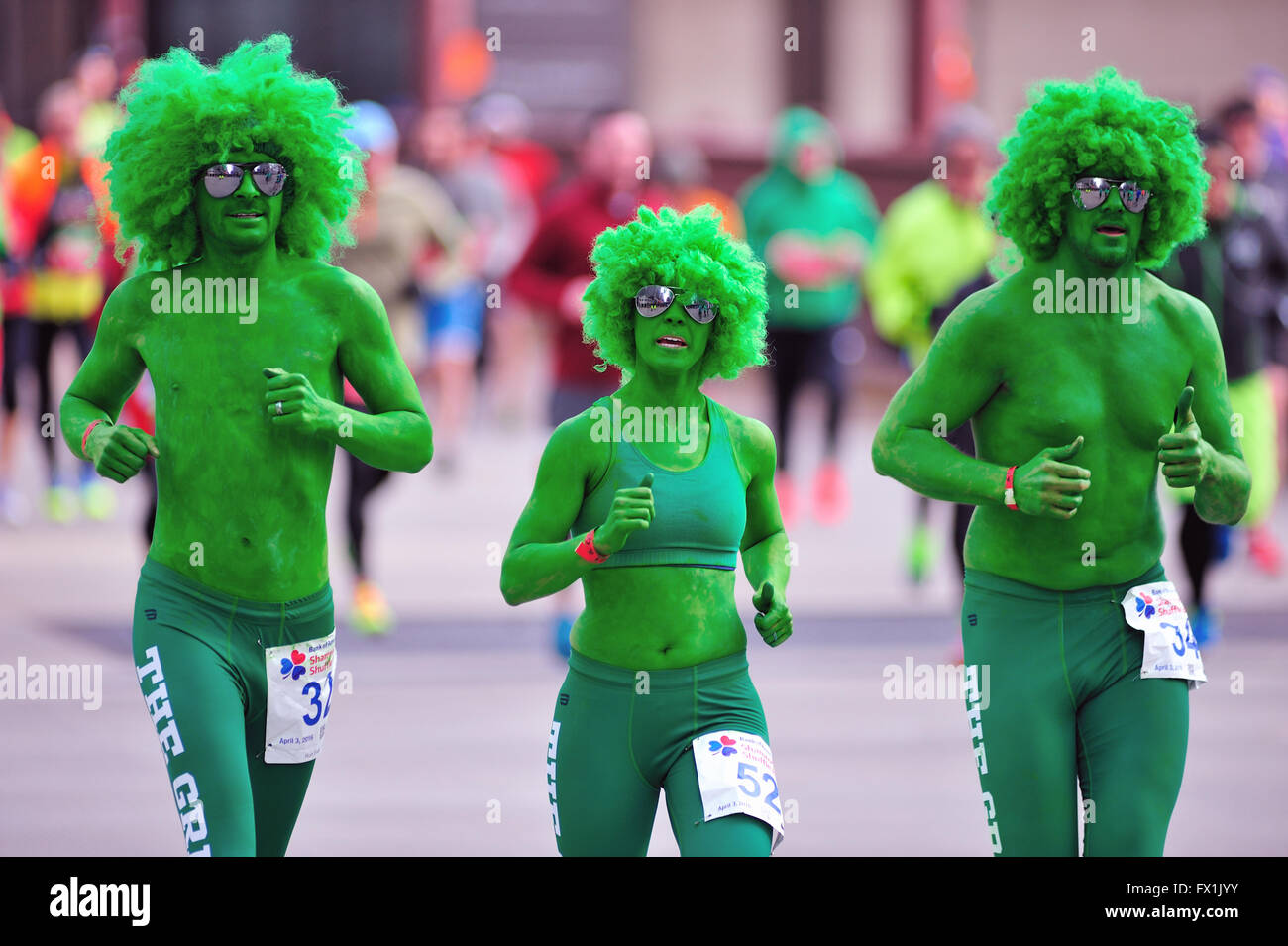 Ein Trio von Läufern, im Geist der Veranstaltung, der Kreuzung der State Street Brücke während der Shamrock Shuffle Rennen in Chicago, Illinois, USA. Stockfoto